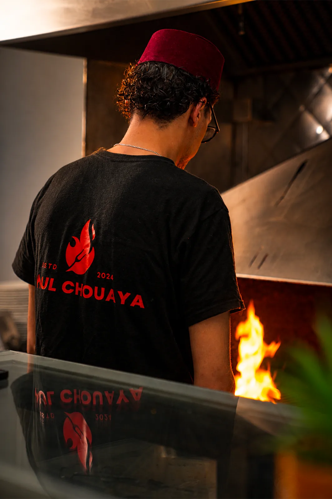Grilladin Moul Chouaya devant le feu de la cuisine