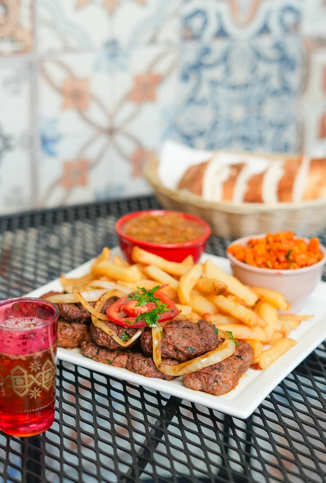 Plat de kefta grillée avec frites, salades marocaines et thé