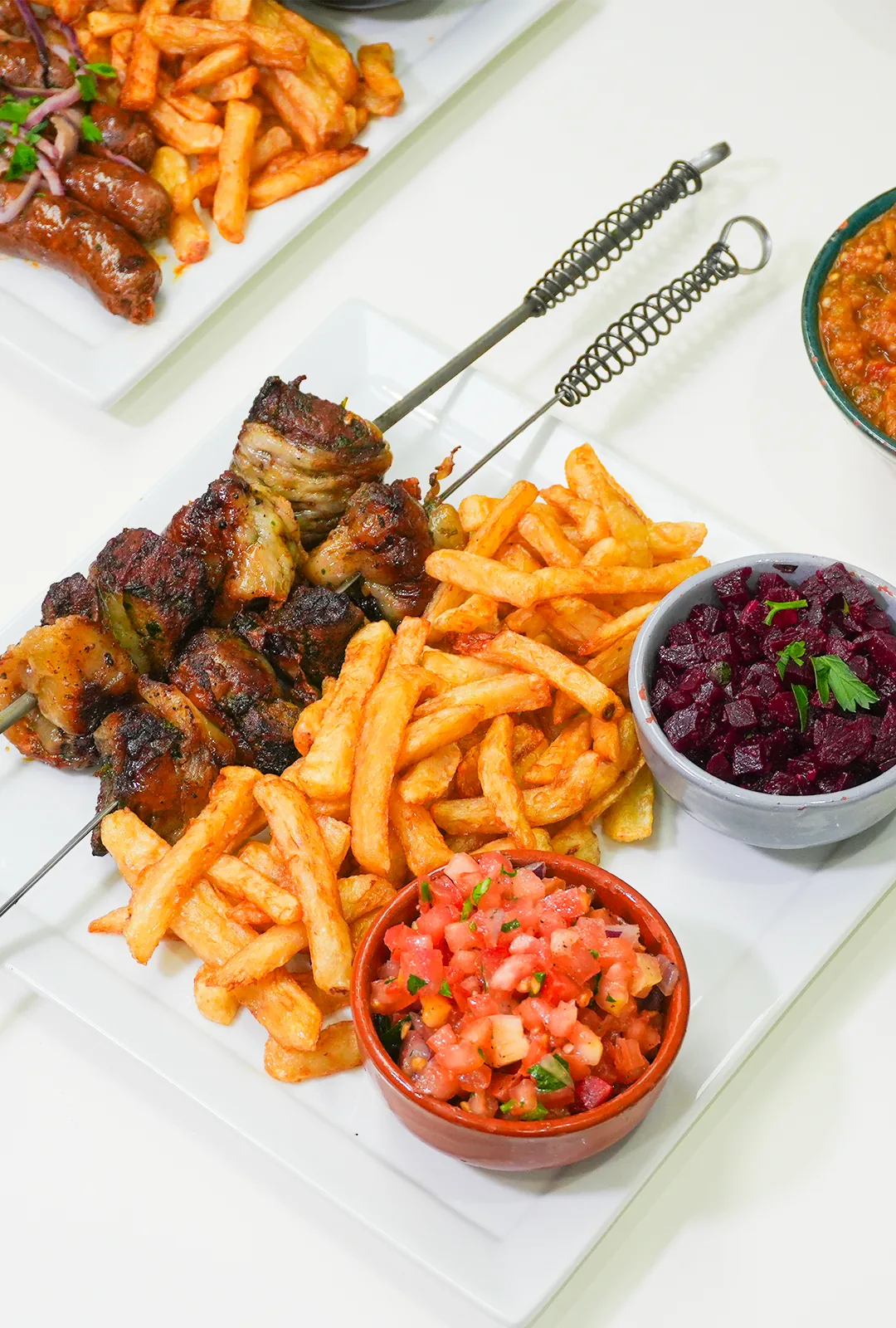 Plat de boulfaf grillé avec frites et salades marocaines